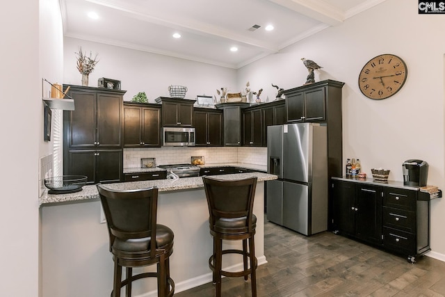 122 Azur Ave, Chapin, SC 29036 - kitchen with appliances with stainless steel finishes, beam ceiling, dark wood finished floors, tasteful backsplash, and a breakfast bar