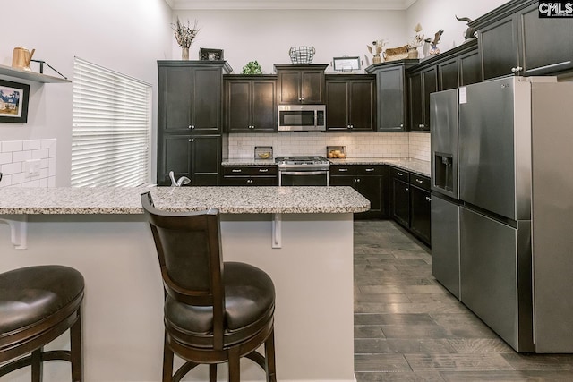 122 Azur Ave, Chapin, SC 29036 - kitchen featuring stainless steel appliances, ornamental molding, decorative backsplash, a breakfast bar area, and a peninsula