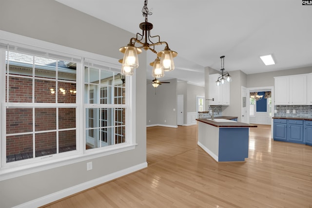 100 Ridge Top Rd, Lexington, SC 29072 - kitchen featuring a chandelier, blue cabinetry, a ceiling fan, light wood-style floors, and backsplash