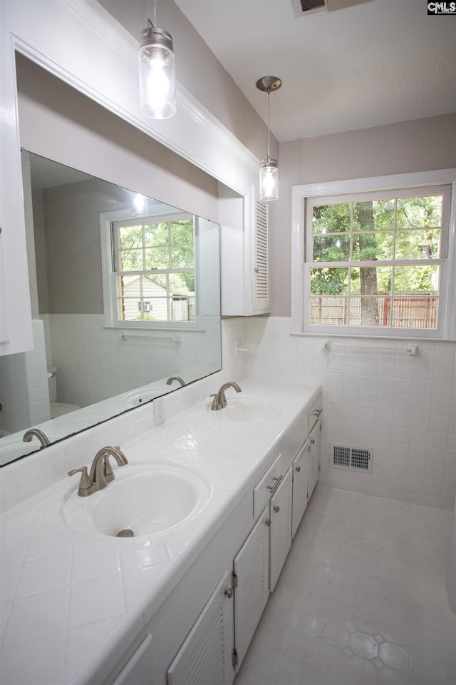 320 Perkins Ln, Camden, SC 29020 - bathroom with plenty of natural light, double vanity, tile walls, tile patterned flooring, and wainscoting