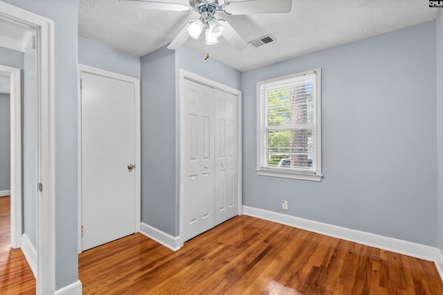 231 Horseshoe Cir, Columbia, SC 29223 - unfurnished bedroom with wood finished floors, a closet, a textured ceiling, and ceiling fan