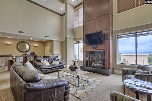 601 Main St Unit 518, Columbia, SC 29201 - living area featuring a high ceiling, light carpet, a large fireplace, and ornamental molding