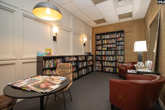 619 King St Unit 801, Columbia, SC 29205 - sitting room with wall of books, a paneled ceiling, and carpet