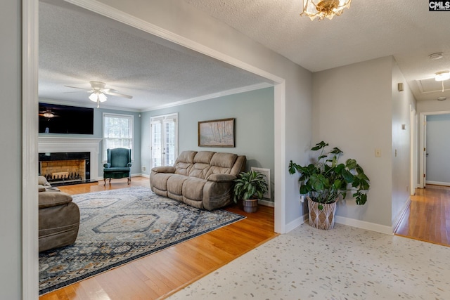9628 Highgate Rd, Columbia, SC 29223 - living room with a textured ceiling, attic access, a ceiling fan, crown molding, and a fireplace with raised hearth