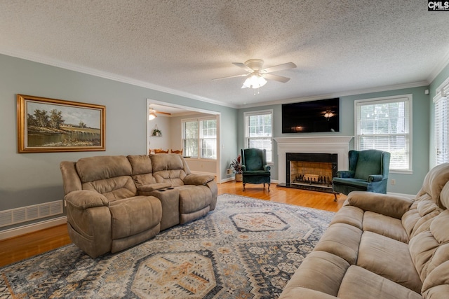 9628 Highgate Rd, Columbia, SC 29223 - living room featuring ceiling fan, ornamental molding, wood finished floors, a fireplace with raised hearth, and a textured ceiling