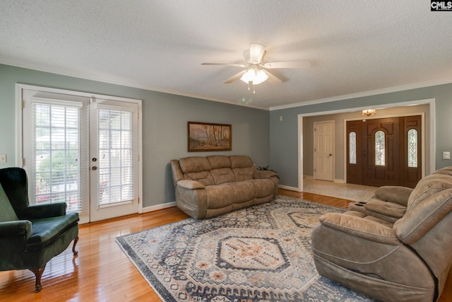 9628 Highgate Rd, Columbia, SC 29223 - living room featuring a textured ceiling, ornamental molding, a ceiling fan, light wood finished floors, and french doors