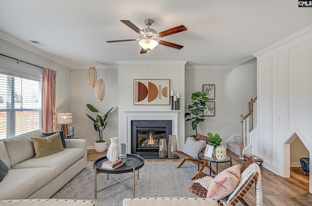2095 County Line Trl, Elgin, SC 29045 - living area with light wood-type flooring, a ceiling fan, stairway, ornamental molding, and a glass covered fireplace
