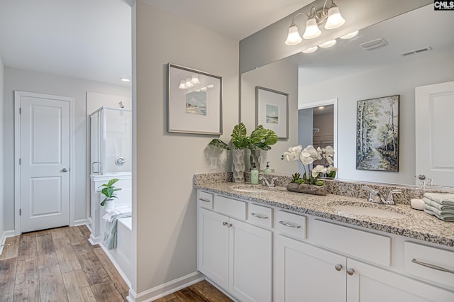 2095 County Line Trl, Elgin, SC 29045 - bathroom with double vanity, a shower stall, wood finished floors, and a garden tub
