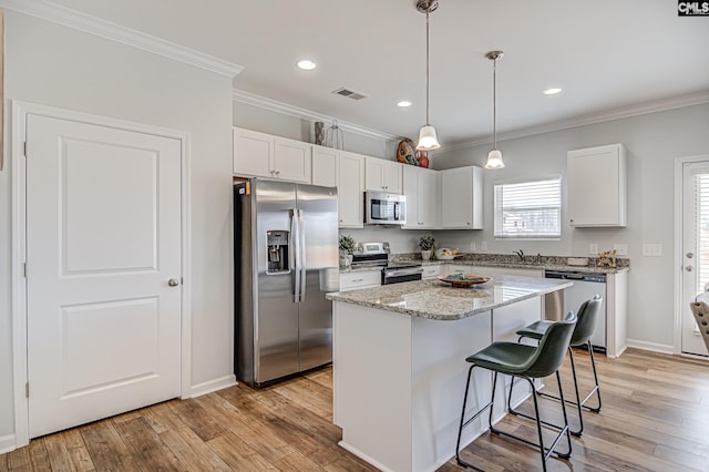 2095 County Line Trl, Elgin, SC 29045 - kitchen featuring stainless steel appliances, ornamental molding, a kitchen island, a kitchen breakfast bar, and light wood-type flooring