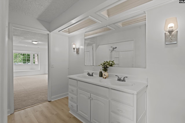 4405 Palmetto Ave, Columbia, SC 29203 - bathroom featuring a textured ceiling, double vanity, and wood finished floors