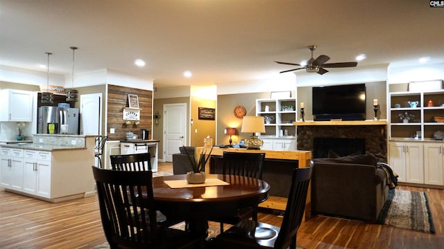 2367 Mount Pilgrim Church Rd, Prosperity, SC 29127 - dining room featuring light wood-style flooring, a ceiling fan, a fireplace, and recessed lighting