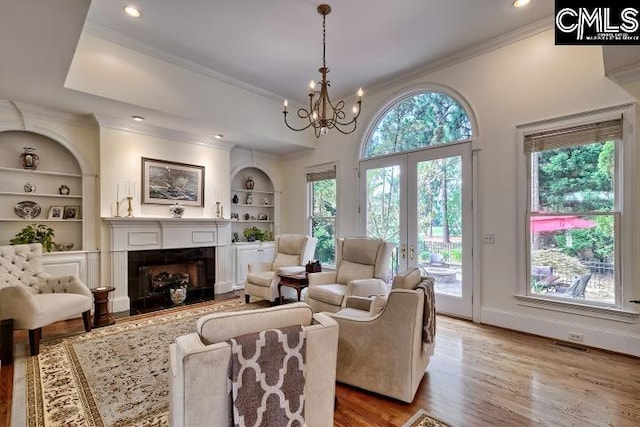 426 Turkey Point Cir, Columbia, SC 29223 - living area with crown molding, built in features, a fireplace with flush hearth, wood finished floors, and a chandelier