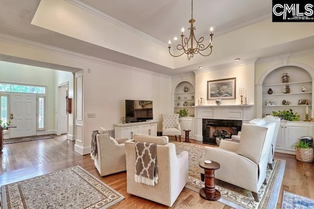 426 Turkey Point Cir, Columbia, SC 29223 - living room featuring ornamental molding, built in features, a chandelier, light wood finished floors, and a fireplace