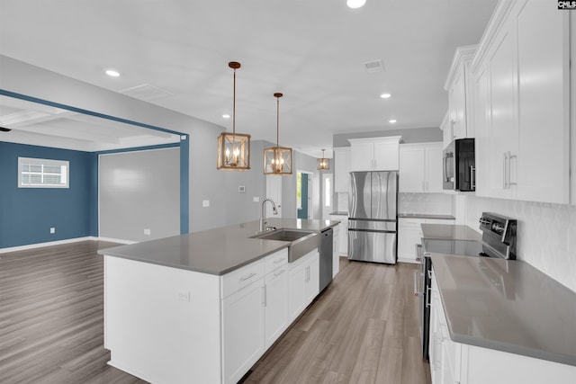4040 Summerland Way, Elgin, SC 29045 - kitchen featuring appliances with stainless steel finishes, backsplash, wood finished floors, white cabinetry, and a chandelier