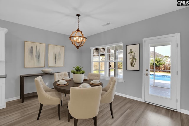 4040 Summerland Way, Elgin, SC 29045 - dining space with light wood finished floors, a chandelier, and healthy amount of natural light