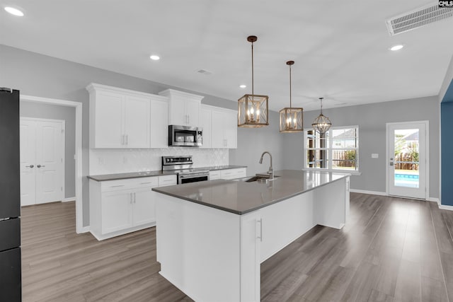 4040 Summerland Way, Elgin, SC 29045 - kitchen featuring appliances with stainless steel finishes, decorative backsplash, wood finished floors, a chandelier, and recessed lighting