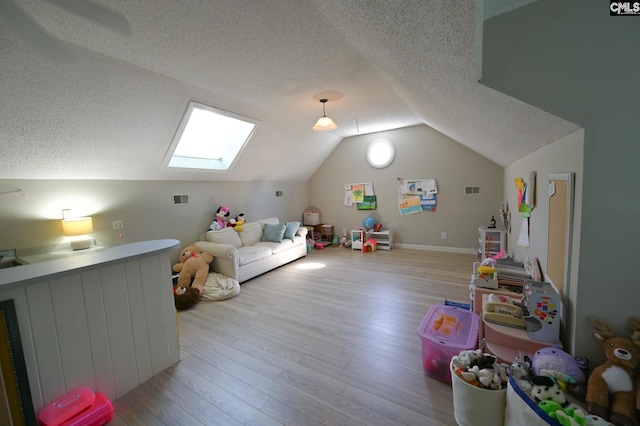 77 Olde Springs Rd, Columbia, SC 29223 - rec room with a textured ceiling, vaulted ceiling, a skylight, and light wood-type flooring