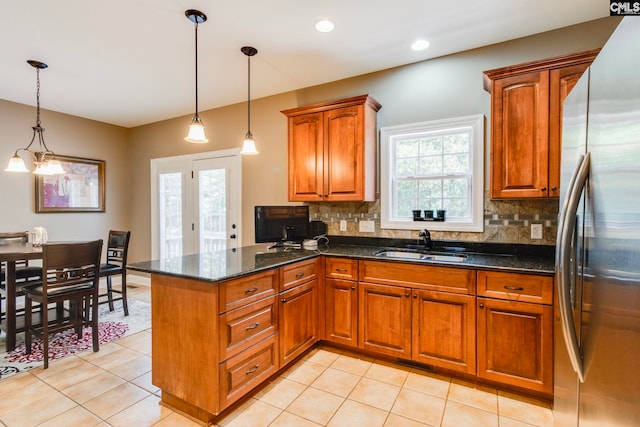487 Marsh Pointe Dr, Columbia, SC 29229 - kitchen featuring freestanding refrigerator, brown cabinetry, a peninsula, decorative backsplash, and hanging light fixtures
