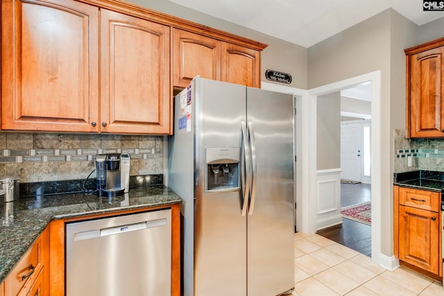 487 Marsh Pointe Dr, Columbia, SC 29229 - kitchen featuring stainless steel appliances, light tile patterned floors, tasteful backsplash, dark stone counters, and wainscoting