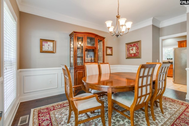 487 Marsh Pointe Dr, Columbia, SC 29229 - dining space with a chandelier, ornamental molding, light wood-style flooring, wainscoting, and a decorative wall