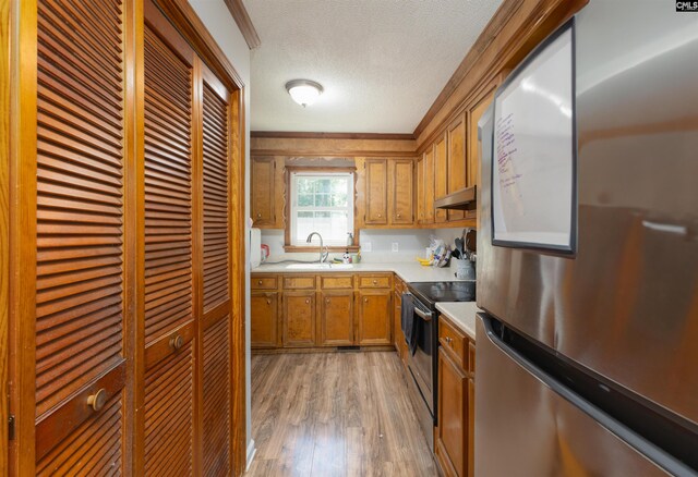 131 Firebranch St, Columbia, SC 29212 - kitchen with appliances with stainless steel finishes, under cabinet range hood, brown cabinets, light wood-style floors, and light countertops
