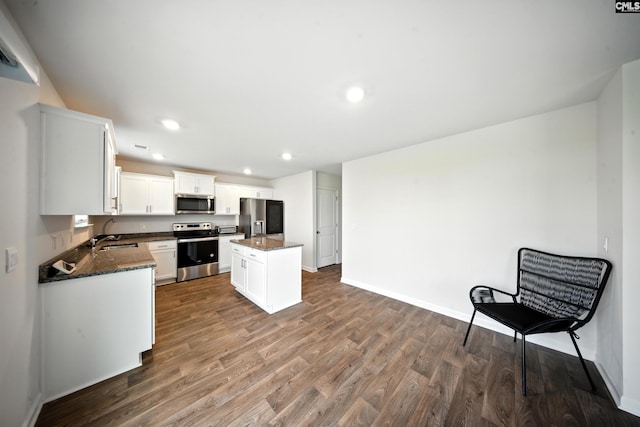 2416 Newberry Landing Cir, Newberry, SC 29108 - kitchen featuring appliances with stainless steel finishes, dark wood-type flooring, a kitchen island, recessed lighting, and white cabinets
