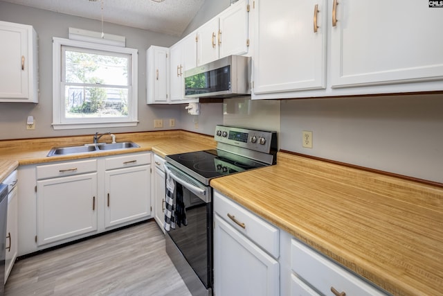1426 B Ave, West Columbia, SC 29169 - kitchen with stainless steel appliances, white cabinets, light countertops, a textured ceiling, and light wood-style floors