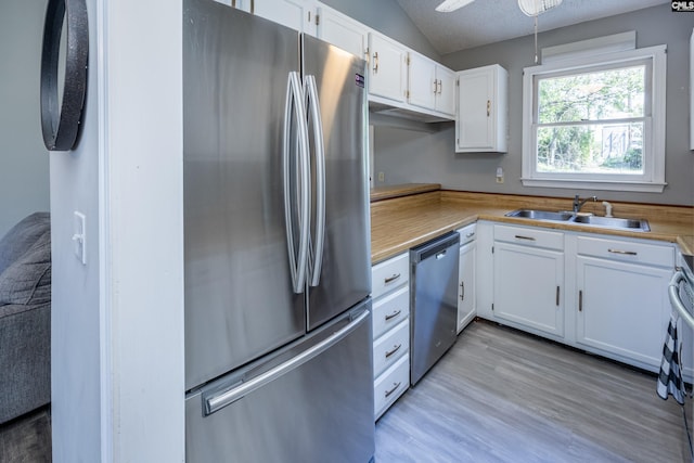 1426 B Ave, West Columbia, SC 29169 - kitchen with appliances with stainless steel finishes, vaulted ceiling, white cabinetry, light countertops, and light wood-style floors