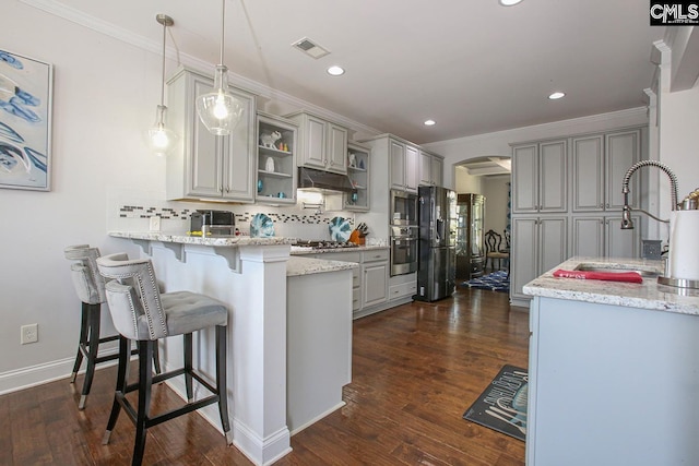 576 Maple Valley Loop, Blythewood, SC 29016 - kitchen featuring appliances with stainless steel finishes, a peninsula, under cabinet range hood, tasteful backsplash, and a breakfast bar