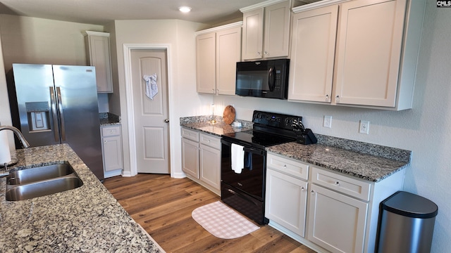 255 Common Reed Dr, Gilbert, SC 29054 - kitchen featuring black appliances, wood finished floors, stone countertops, recessed lighting, and white cabinetry
