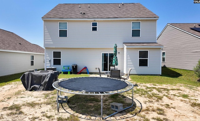 255 Common Reed Dr, Gilbert, SC 29054 - rear view of house featuring a trampoline, roof with shingles, and a yard