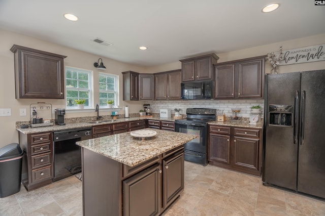 611 Colony Lakes Dr, Lexington, SC 29073 - kitchen with black appliances, dark brown cabinetry, light stone countertops, a kitchen island, and recessed lighting