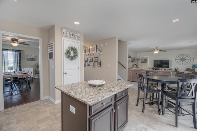 611 Colony Lakes Dr, Lexington, SC 29073 - kitchen with a ceiling fan, open floor plan, light stone counters, a kitchen island, and dark brown cabinets