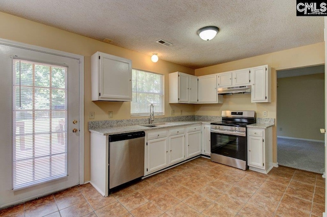 125 Durham Creek Ct, Columbia, SC 29229 - kitchen with appliances with stainless steel finishes, under cabinet range hood, white cabinets, a textured ceiling, and light tile patterned flooring