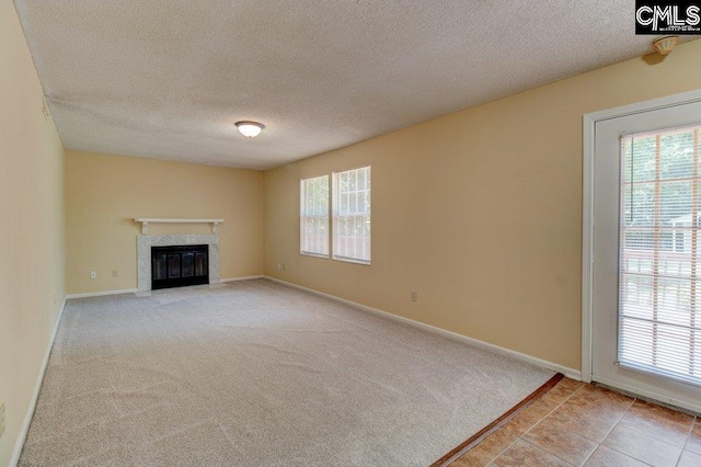 125 Durham Creek Ct, Columbia, SC 29229 - unfurnished living room with healthy amount of natural light, a textured ceiling, a fireplace with flush hearth, and carpet floors