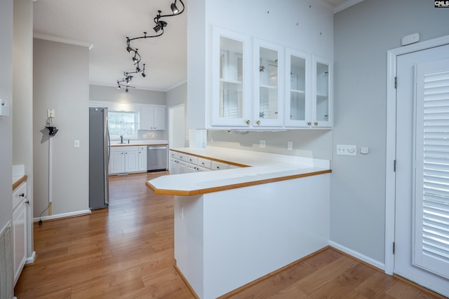 511 Boykin Rd, Extension, Camden, SC 29020 - kitchen featuring appliances with stainless steel finishes, white cabinetry, light wood finished floors, glass insert cabinets, and ornamental molding