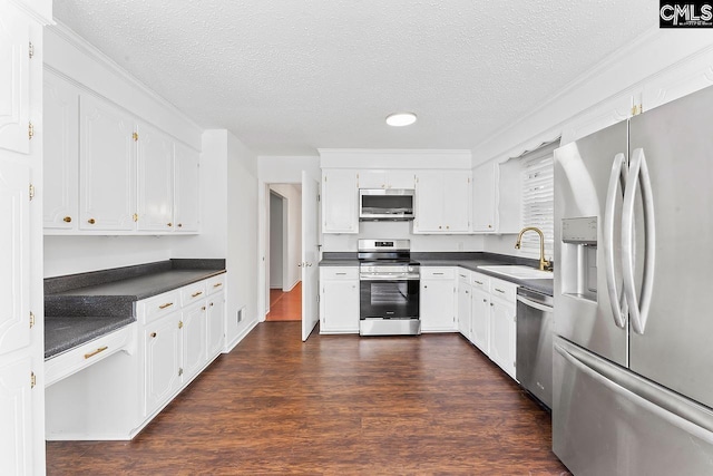 9829 Highgate Rd, Columbia, SC 29223 - kitchen with appliances with stainless steel finishes, dark countertops, dark wood-style flooring, a textured ceiling, and white cabinets