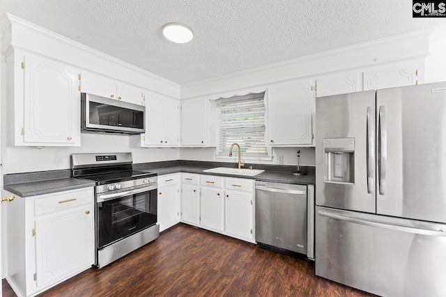 9829 Highgate Rd, Columbia, SC 29223 - kitchen featuring appliances with stainless steel finishes, a textured ceiling, dark countertops, dark wood-style floors, and white cabinets