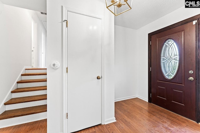 9829 Highgate Rd, Columbia, SC 29223 - entrance foyer with wood finished floors, a chandelier, stairway, and a textured ceiling