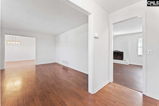 9829 Highgate Rd, Columbia, SC 29223 - empty room featuring a textured ceiling, wood finished floors, and a fireplace