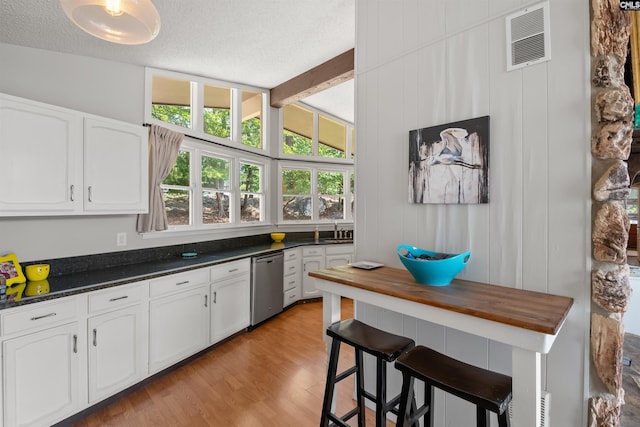 732 Nichols Ct, Leesville, SC 29070 - kitchen with dishwasher, white cabinets, healthy amount of natural light, beamed ceiling, and a textured ceiling