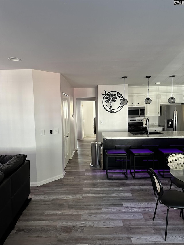 5 Battery Walk Ct Unit B, Columbia, SC 29212 - kitchen with appliances with stainless steel finishes, dark wood finished floors, light countertops, a kitchen breakfast bar, and white cabinets