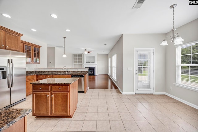 267 Caedmons Creek Dr, Irmo, SC 29063 - kitchen featuring appliances with stainless steel finishes, a peninsula, a fireplace, a ceiling fan, and healthy amount of natural light