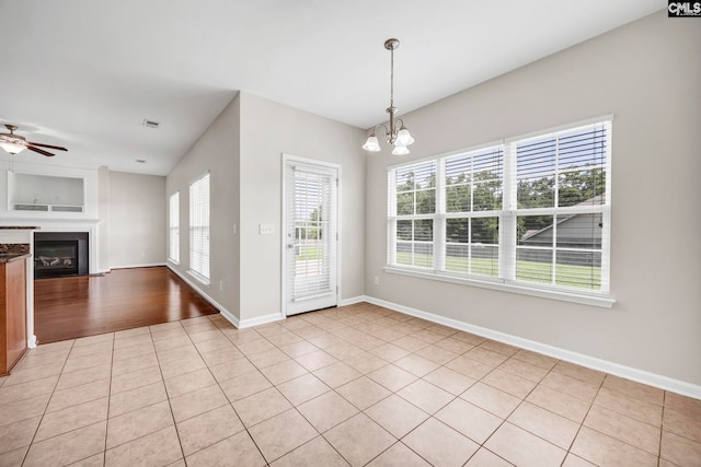 267 Caedmons Creek Dr, Irmo, SC 29063 - unfurnished dining area featuring a chandelier, ceiling fan, light tile patterned floors, and a glass covered fireplace