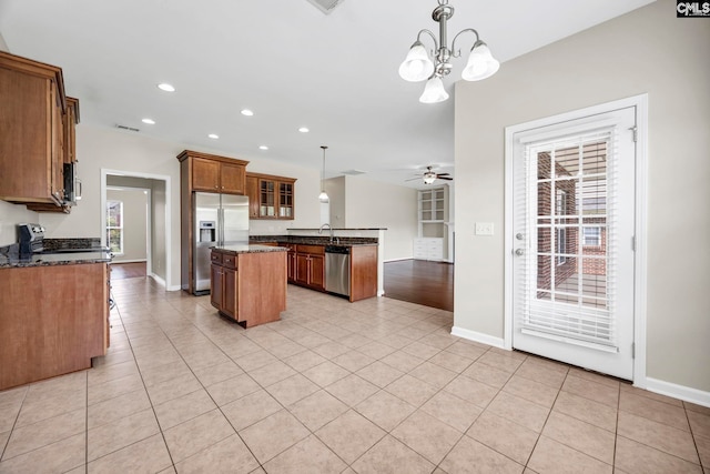 267 Caedmons Creek Dr, Irmo, SC 29063 - kitchen with stainless steel appliances, a center island, brown cabinetry, light tile patterned floors, and recessed lighting