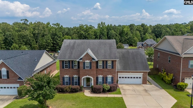267 Caedmons Creek Dr, Irmo, SC 29063 - colonial home featuring brick siding, concrete driveway, a front yard, a garage, and a view of trees