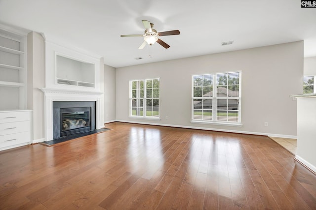 267 Caedmons Creek Dr, Irmo, SC 29063 - unfurnished living room featuring a fireplace with flush hearth, a ceiling fan, wood finished floors, and built in shelves