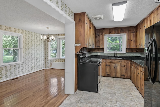 4614 Briarfield Rd, Columbia, SC 29206 - kitchen featuring black appliances, a textured ceiling, dark countertops, a chandelier, and brown cabinets
