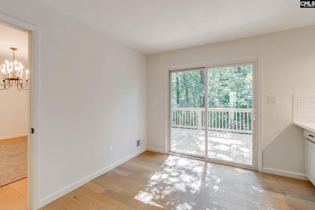 2214 Elkridge Dr, Camden, SC 29020 - unfurnished room with light wood-style floors and a chandelier