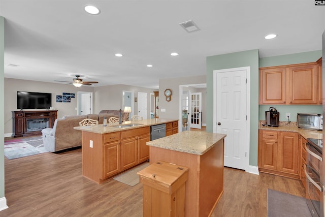 1140 Counts Ferry Rd, Lexington, SC 29072 - kitchen featuring a center island with sink, a ceiling fan, open floor plan, light wood finished floors, and light stone countertops